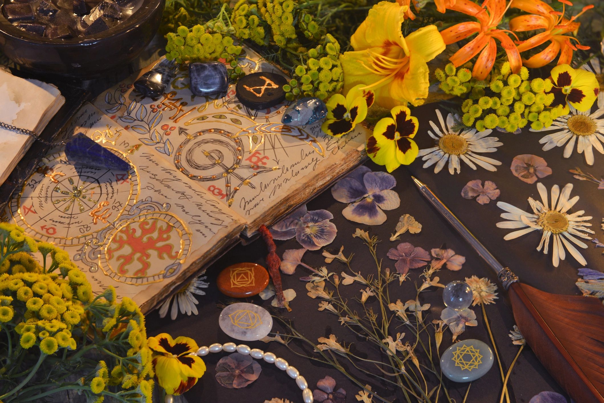 Mystic still life with open magic book of spells, flowers, crystals, black candles and witchy ritual objects on old table. Occult, esoteric, gothic and wicca concept