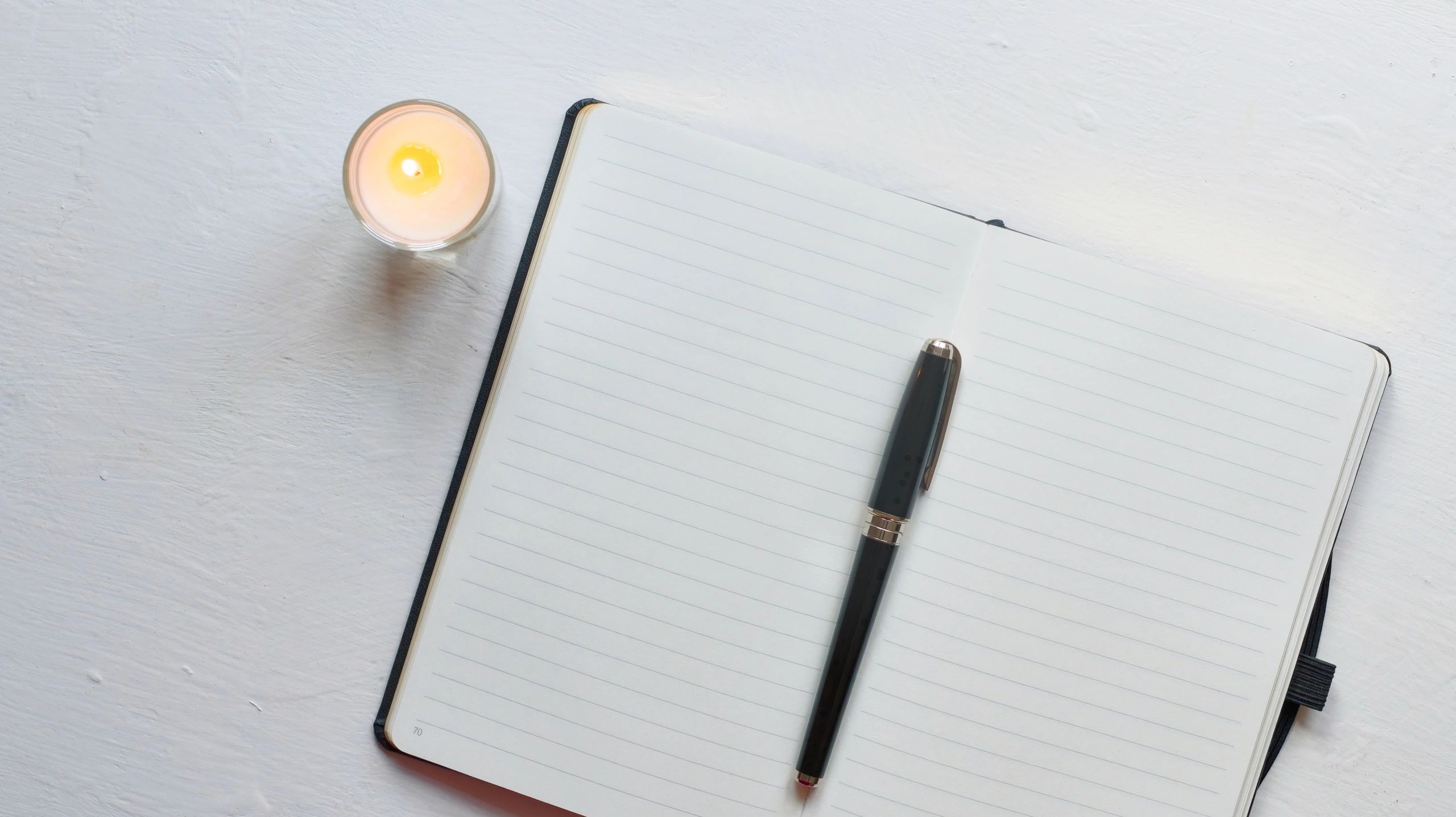 Notebook and candle arranged for reflective journaling